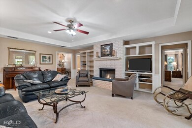 Carpeted living room with a tray ceiling, a firepl