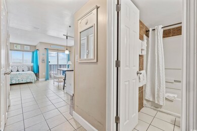 Corridor with light tile patterned flooring and ba