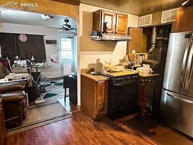 Kitchen featuring ceiling fan, range, dark hardwoo
