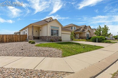 View of front of property featuring stone siding, driveway, and an attached garage