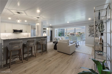 Living area featuring light wood-type flooring and ornamental molding
