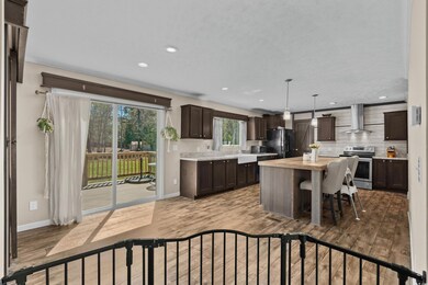 Kitchen featuring wall chimney exhaust hood, stainless steel range with electric cooktop, dark brown cabinetry, black refrigerator with ice dispenser, and backsplash