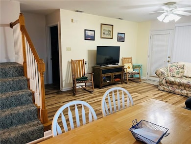Living area with a ceiling fan, light wood-style f