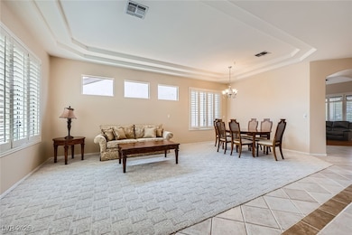 Living room featuring a chandelier, a raised ceili