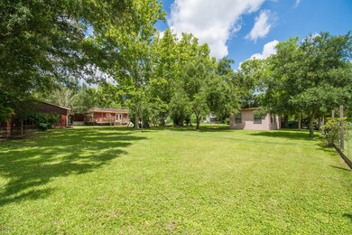 The rear view of home shows fruit trees, grape vin