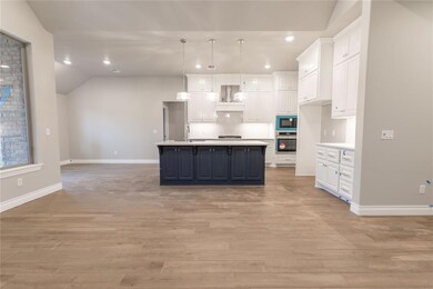 Kitchen featuring white cabinetry, black microwave