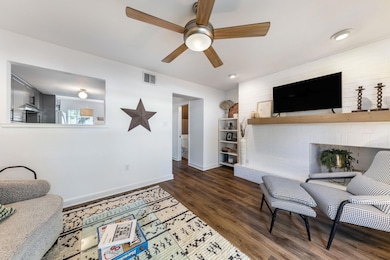 Living room featuring a ceiling fan, a fireplace,