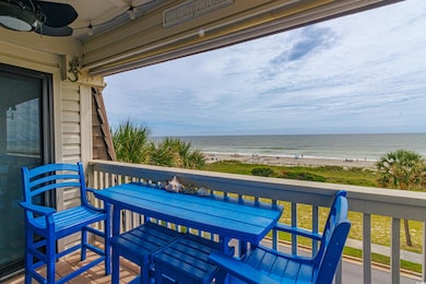 Balcony featuring a water view, a beach view, and ceiling fan