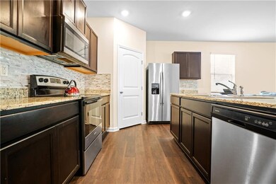 Kitchen featuring stainless steel appliances, dark