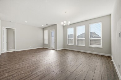 Empty room featuring a chandelier, wood finish floors, and recessed lighting