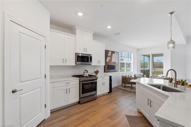 Kitchen featuring white cabinetry, sink, stainless
