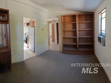 Unfurnished living room featuring lofted ceiling and light colored carpet