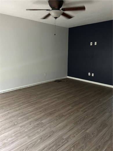 Spare room with wood finished floors, ceiling fan,