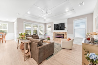 Living room with a fireplace, ceiling fan, visible