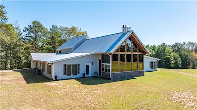 Rear view of house featuring a yard, a sunroom, an