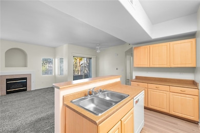 Kitchen with light brown cabinets, a sink, white d