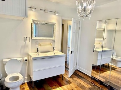 Full bathroom with double vanity, hardwood / wood