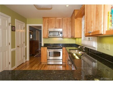 The kitchen is renovated with new cabinetry, stainless steel appliances, hardwood floors and granite counter tops.