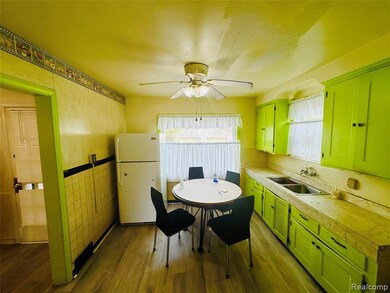 Kitchen with green cabinetry, light countertops, freestanding refrigerator, dark wood-style floors, and tile walls