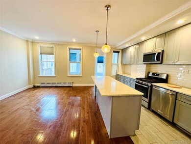 Kitchen featuring crown molding, gray cabinets, appliances with stainless steel finishes, tasteful backsplash, and a kitchen island