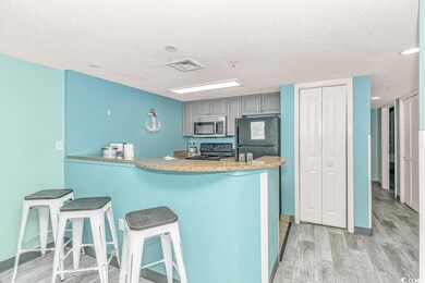 Kitchen featuring gray cabinets, range, light wood