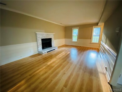 Unfurnished living room with ornamental molding, light hardwood flooring, and a fireplace