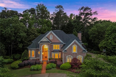 View of front of home featuring a chimney, brick s
