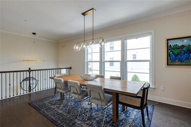 Dining area with dark wood finished floors, baseboards, and crown molding
