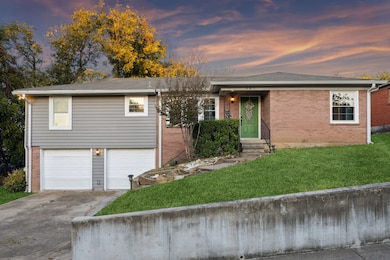 Ranch-style home featuring driveway, a lawn, brick siding, and a garage