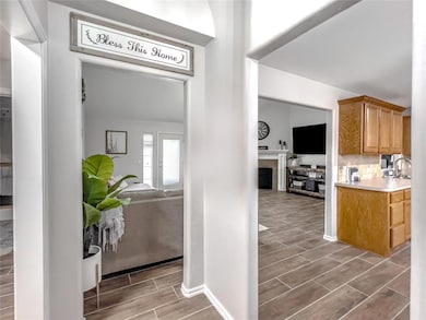 Kitchen with wood tiled floors, light countertops, a fireplace, and brown cabinets