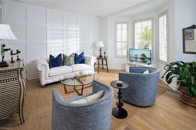 Living area with plenty of natural light, a decorative wall, wood finished floors, and baseboards
