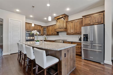 Kitchen featuring a center island with sink, dark 