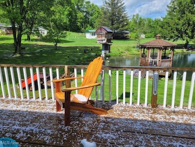 Wooden terrace featuring a gazebo, a lawn, and a water view