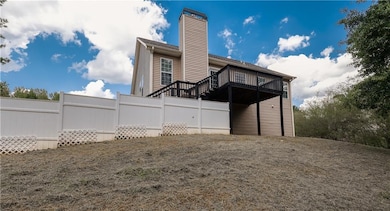 Rear view of property featuring a chimney and a deck
