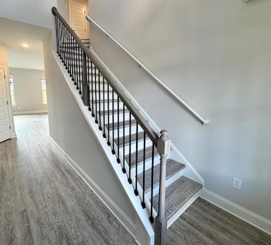 Stairs featuring wood finished floors, baseboards,