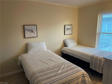 Bedroom with ornamental molding and wood finished floors