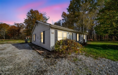 Property exterior at dusk featuring a lawn
