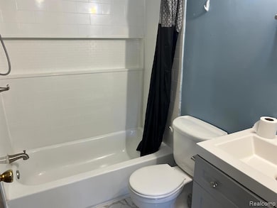 Bathroom featuring shower / bath combination with curtain and vanity
