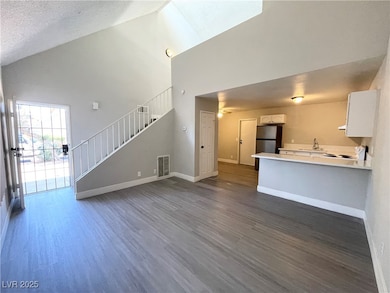 Unfurnished living room with high vaulted ceiling,