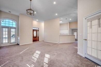 Unfurnished living room featuring a chandelier and