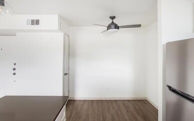 Unfurnished room with a ceiling fan, dark wood-sty