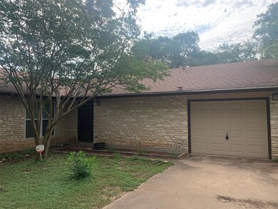 View of front of home with stone siding, a shingled roof, an attached garage, and concrete driveway
