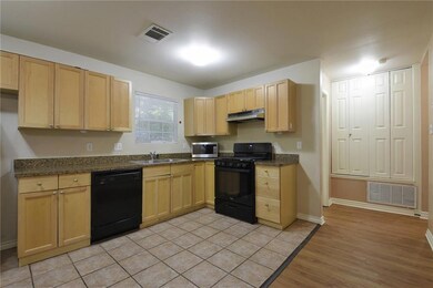 Kitchen featuring visible vents, black appliances