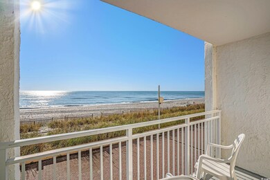 Balcony featuring view of water and beach