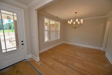 Entryway with plenty of natural light, a chandelier, light wood-style flooring, and ornamental molding