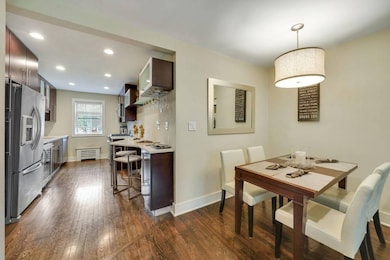 Dining space with dark wood-style flooring and rec
