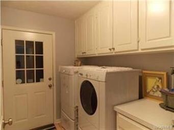Laundry room with cabinets, folding table, broom c