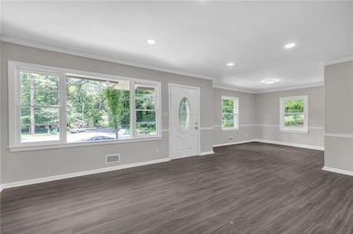 Foyer featuring ornamental molding, dark wood finished floors, and recessed lighting