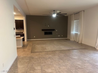 Unfurnished living room with ceiling fan and baseb
