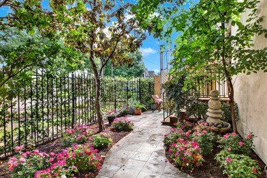 The lush, flower-lined path leads through the gate